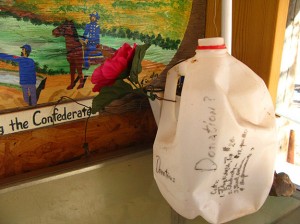 this jug is attached by a wire to the wall and next to a dusty guest book